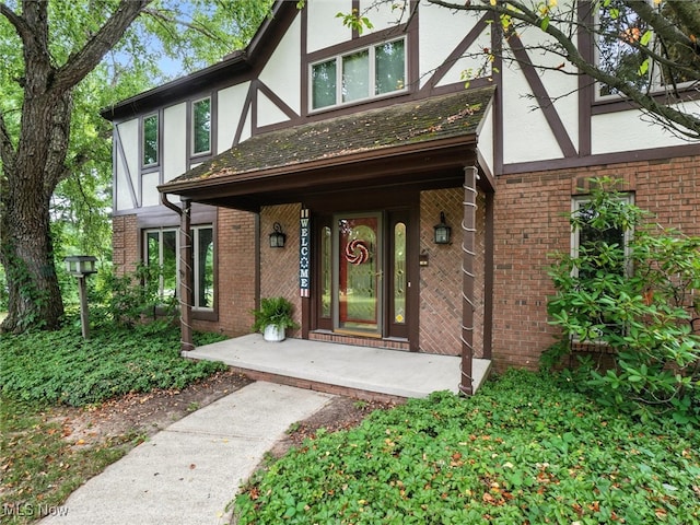19070 Ridgeview Trl, Chagrin Falls, OH 44023 - doorway to property with stucco siding, brick siding, and covered porch