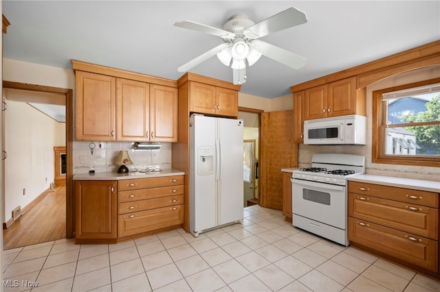 3016 Clague Rd, North Olmsted, OH 44070 - kitchen featuring white appliances, light countertops, tasteful backsplash, ceiling fan, and light tile patterned floors