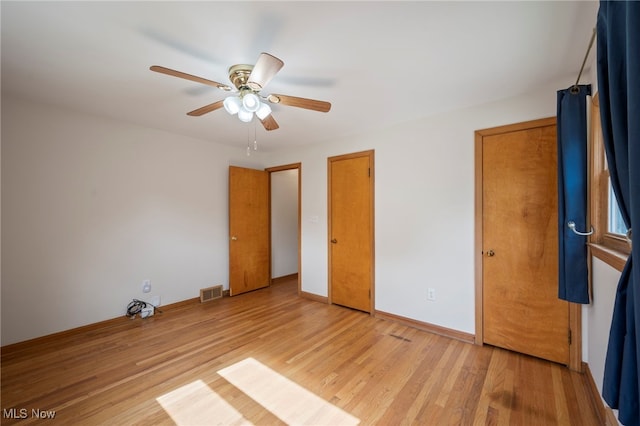 3016 Clague Rd, North Olmsted, OH 44070 - unfurnished bedroom with light wood finished floors, two closets, and a ceiling fan