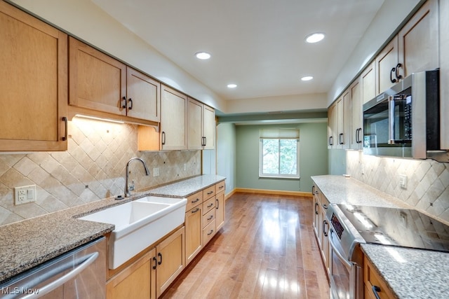1012 Bunker Dr Unit 307, Akron, OH 44333 - kitchen featuring stainless steel appliances, light wood finished floors, light stone counters, recessed lighting, and tasteful backsplash
