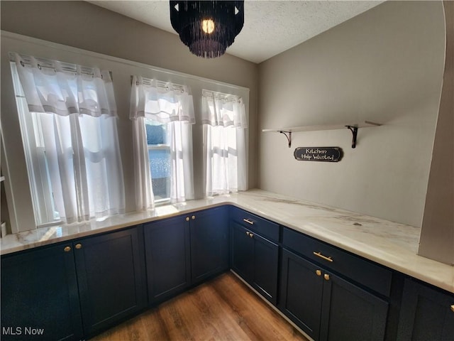343 Genesee Ave NE, Warren, OH 44483 - kitchen featuring open shelves, blue cabinets, wood finished floors, light countertops, and a textured ceiling