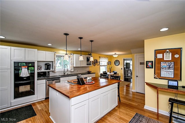 4219 3rd St NW, Canton, OH 44708 - kitchen featuring dishwasher, butcher block counters, light wood finished floors, white cabinets, and recessed lighting