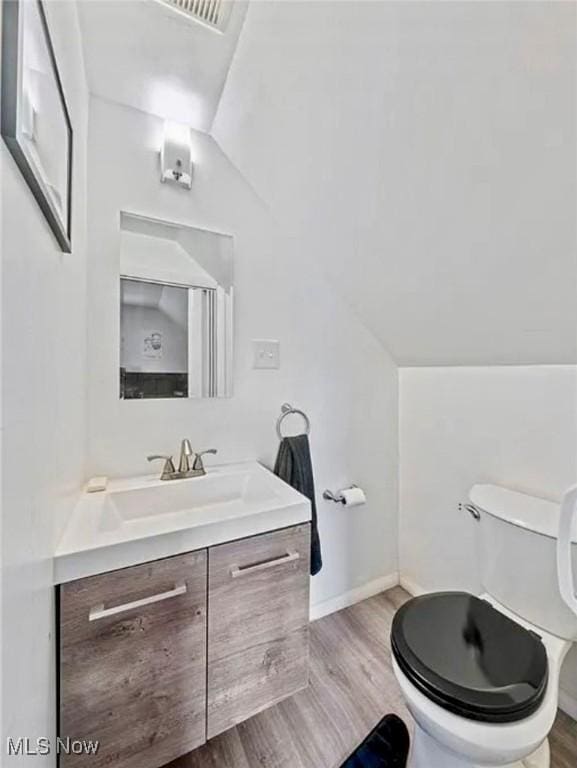 4611 W 158th St, Cleveland, OH 44135 - bathroom featuring vanity, wood finished floors, and vaulted ceiling