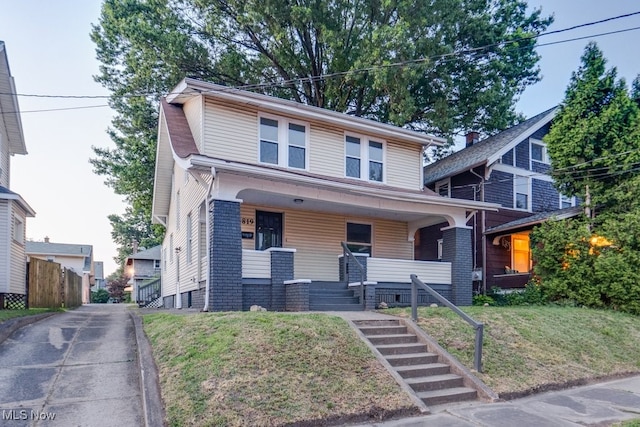 2819 4th St NW, Canton, OH 44708 - traditional style home featuring a porch, a front lawn, and stairway