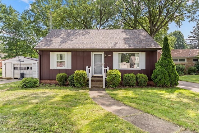 2330 Parkway Blvd, Alliance, OH 44601 - bungalow featuring an outdoor structure, a garage, a front yard, and a shingled roof