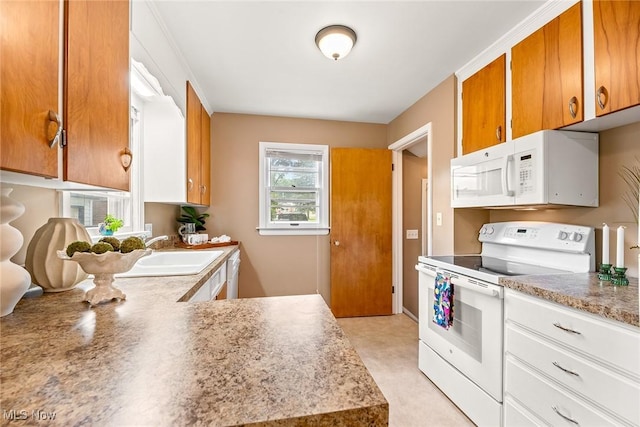 2330 Parkway Blvd, Alliance, OH 44601 - kitchen with white appliances, brown cabinetry, and light countertops