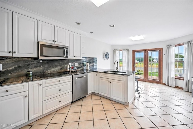 6388 Brianna Way NW, Warren, OH 44481 - kitchen with appliances with stainless steel finishes, a peninsula, backsplash, plenty of natural light, and recessed lighting