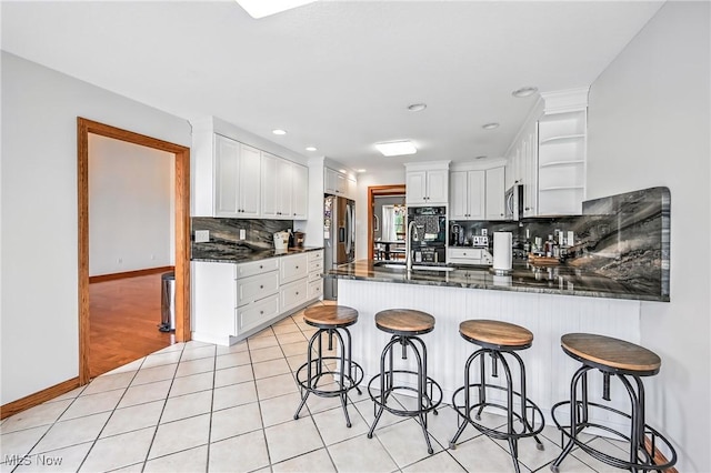 6388 Brianna Way NW, Warren, OH 44481 - kitchen with open shelves, a peninsula, backsplash, appliances with stainless steel finishes, and white cabinetry