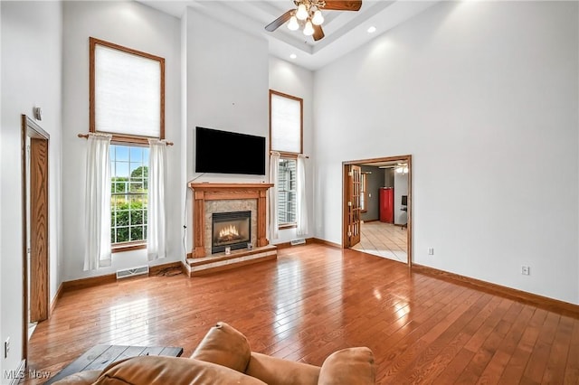 6388 Brianna Way NW, Warren, OH 44481 - living area featuring a high ceiling, a ceiling fan, hardwood / wood-style flooring, and a glass covered fireplace