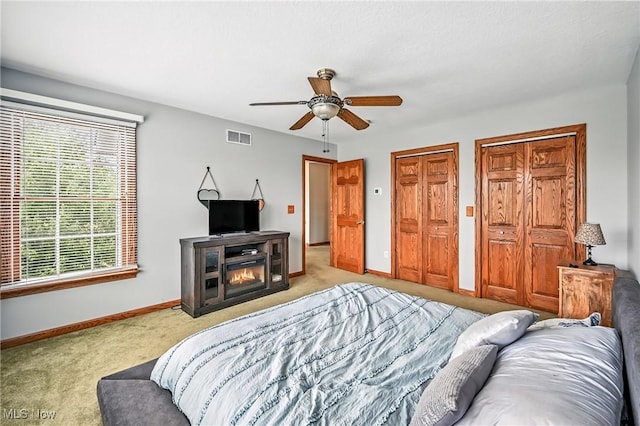 6388 Brianna Way NW, Warren, OH 44481 - carpeted bedroom featuring two closets, ceiling fan, and a fireplace