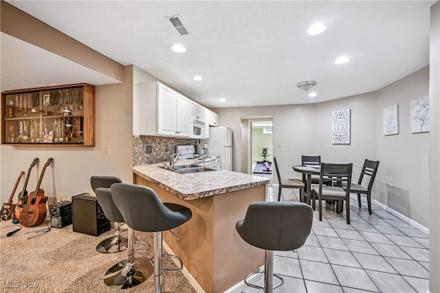 6388 Brianna Way NW, Warren, OH 44481 - kitchen featuring white appliances, white cabinets, light countertops, recessed lighting, and a kitchen breakfast bar