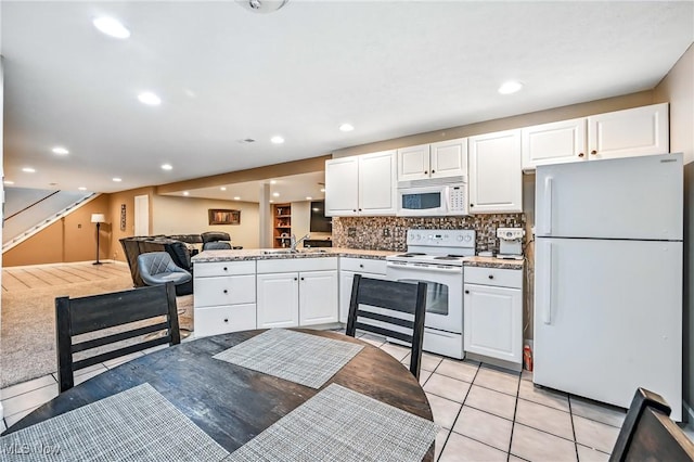 6388 Brianna Way NW, Warren, OH 44481 - kitchen featuring white appliances, white cabinets, decorative backsplash, open floor plan, and light tile patterned floors