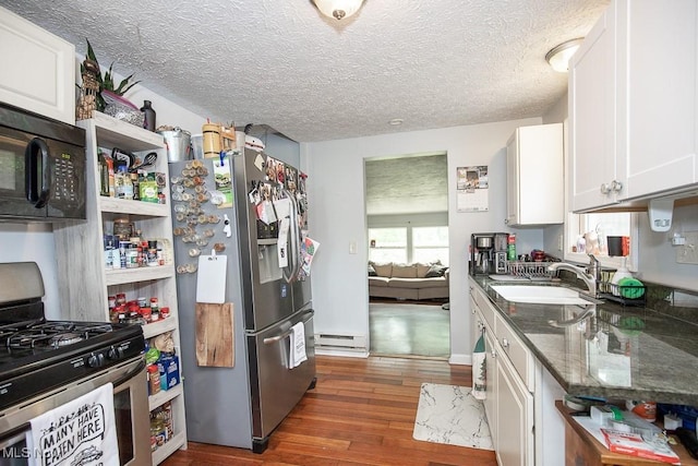 195 S Point Dr, Avon Lake, OH 44012 - kitchen with appliances with stainless steel finishes, white cabinetry, dark wood-style floors, a baseboard heating unit, and a textured ceiling