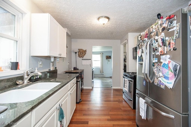 195 S Point Dr, Avon Lake, OH 44012 - kitchen featuring appliances with stainless steel finishes, white cabinets, wood finished floors, a textured ceiling, and dark stone countertops
