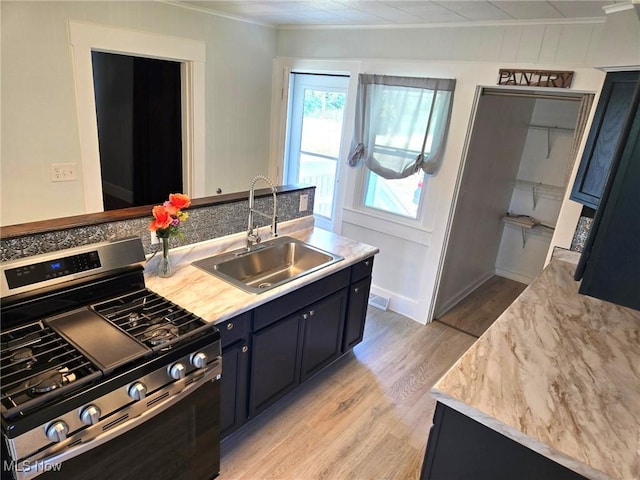 3986 Newton Falls Bailey Rd, Newton Falls, OH 44444 - kitchen with stainless steel gas range oven, crown molding, light wood-style floors, light countertops, and dark cabinets
