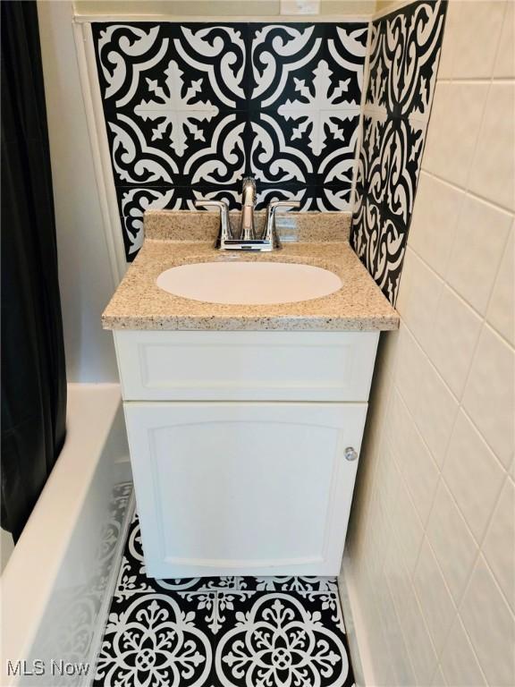 3986 Newton Falls Bailey Rd, Newton Falls, OH 44444 - full bath featuring vanity, tile patterned flooring, a bath, and tile walls