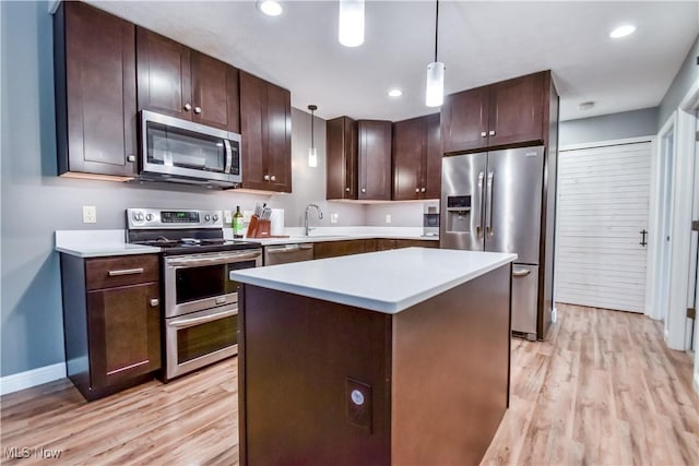 7208 S Galahad Pl, Concord Township, OH 44077 - kitchen featuring stainless steel appliances, light wood finished floors, light countertops, dark brown cabinets, and hanging light fixtures