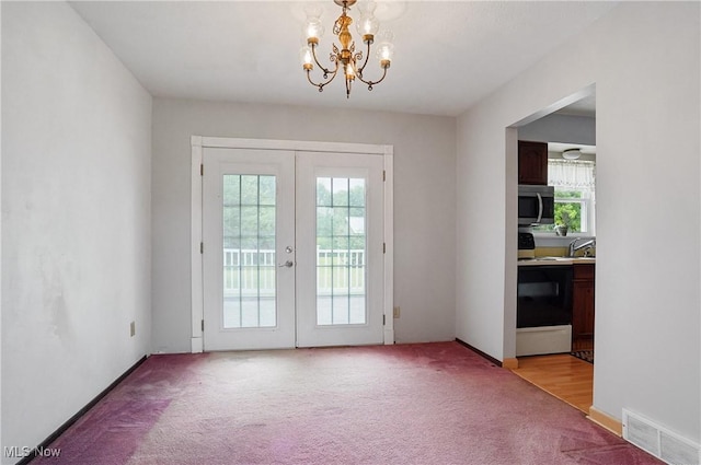12230 Painesville Warren Rd, Concord, OH 44077 - doorway to outside featuring french doors, light colored carpet, and a chandelier
