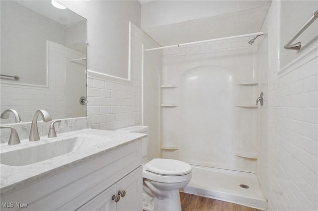 12230 Painesville Warren Rd, Concord, OH 44077 - full bath with tile walls, a shower, vanity, wood finished floors, and wainscoting