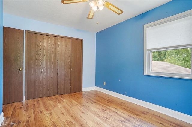 12230 Painesville Warren Rd, Concord, OH 44077 - unfurnished bedroom featuring wood finished floors, a closet, and a ceiling fan