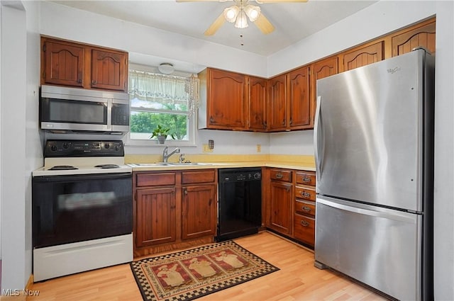 12230 Painesville Warren Rd, Concord, OH 44077 - kitchen featuring appliances with stainless steel finishes, light wood finished floors, light countertops, a ceiling fan, and brown cabinets
