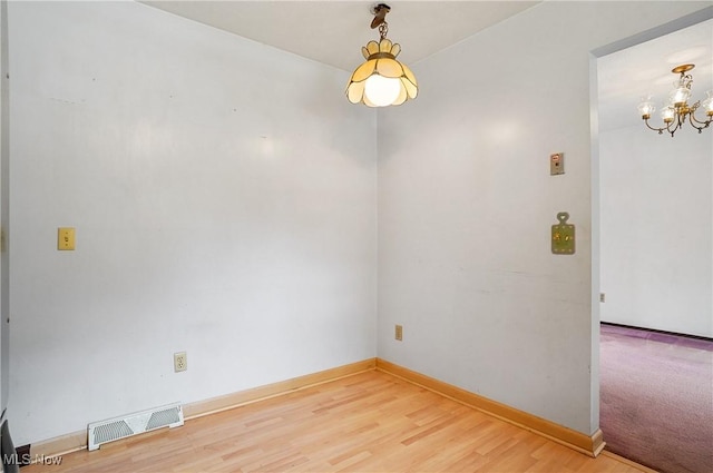 12230 Painesville Warren Rd, Concord, OH 44077 - empty room featuring a chandelier and light wood finished floors
