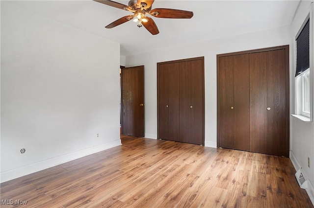 12230 Painesville Warren Rd, Concord, OH 44077 - unfurnished bedroom with two closets, wood finished floors, and ceiling fan
