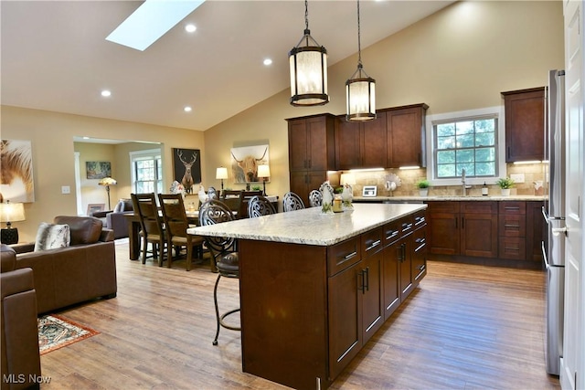 12 Bayview Cir, Cortland, OH 44410 - kitchen with a kitchen breakfast bar, open floor plan, decorative backsplash, light wood-style floors, and high vaulted ceiling