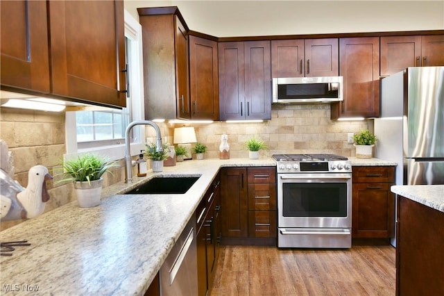 12 Bayview Cir, Cortland, OH 44410 - kitchen with stainless steel appliances, light wood-type flooring, backsplash, and light stone counters