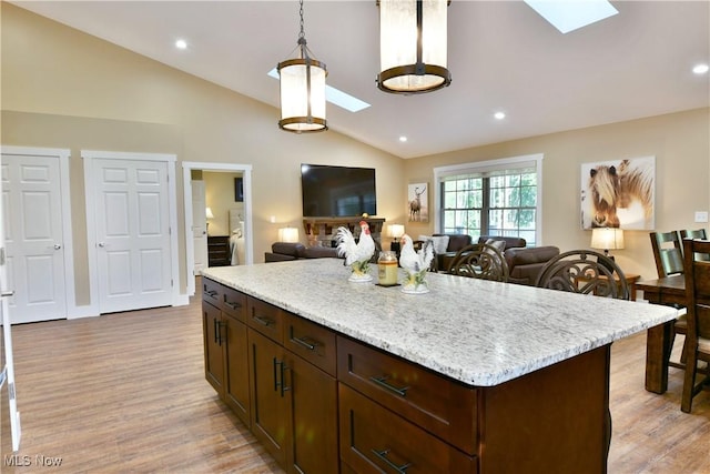 12 Bayview Cir, Cortland, OH 44410 - kitchen featuring a skylight, light wood finished floors, lofted ceiling, open floor plan, and dark brown cabinetry