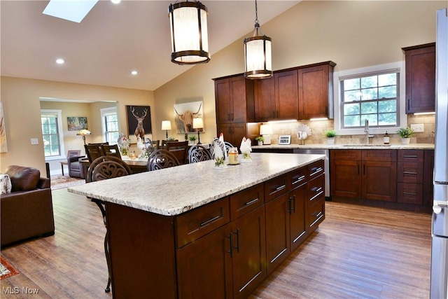 12 Bayview Cir, Cortland, OH 44410 - kitchen featuring stainless steel dishwasher, open floor plan, a kitchen island, a kitchen bar, and backsplash