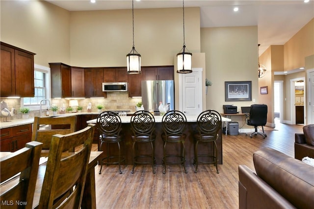 12 Bayview Cir, Cortland, OH 44410 - kitchen with appliances with stainless steel finishes, open floor plan, a high ceiling, light wood-type flooring, and a breakfast bar area