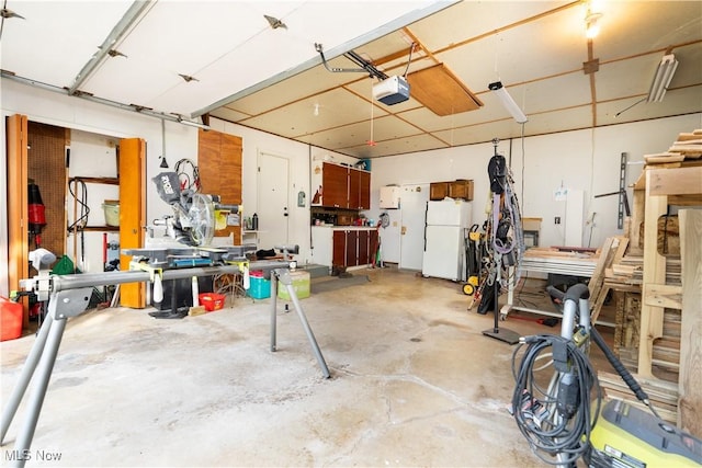 659 Lake Rd, Conneaut, OH 44030 - garage featuring freestanding refrigerator, a garage door opener, and a workshop area
