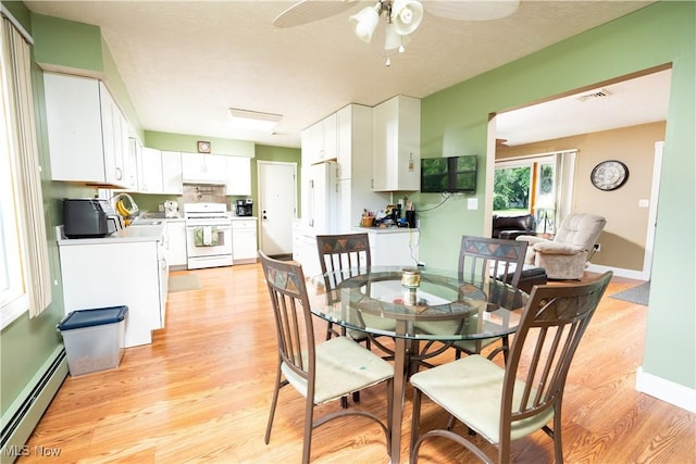659 Lake Rd, Conneaut, OH 44030 - dining space with a baseboard heating unit, light wood-style flooring, and ceiling fan