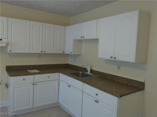 1064 E 168th St, Cleveland, OH 44110 - kitchen featuring dark countertops, white cabinetry, and a textured ceiling