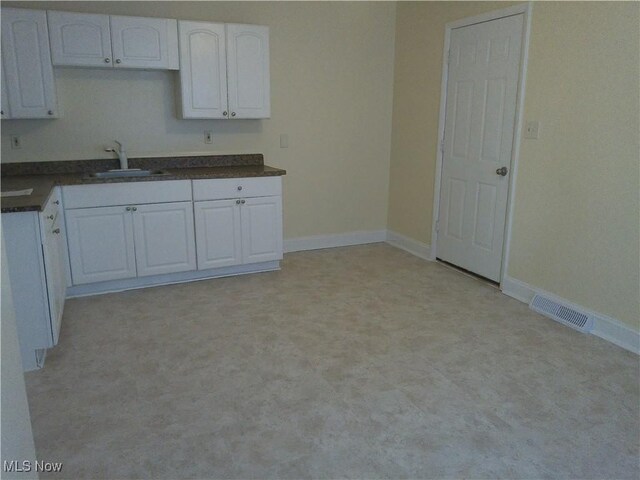 1064 E 168th St, Cleveland, OH 44110 - kitchen featuring dark countertops and white cabinetry