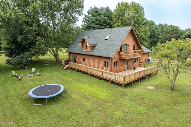5621 Schustrich Rd, Mantua, OH 44255 - rear view of property with a trampoline, a lawn, a shingled roof, and a deck