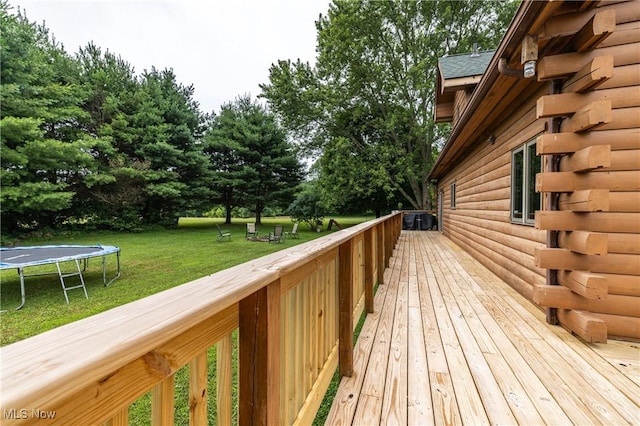 5621 Schustrich Rd, Mantua, OH 44255 - wooden deck featuring a trampoline, a lawn, and view of wooded area