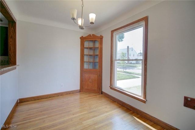 8102 Bertha Ave, Parma, OH 44129 - empty room with light wood-style floors and a chandelier