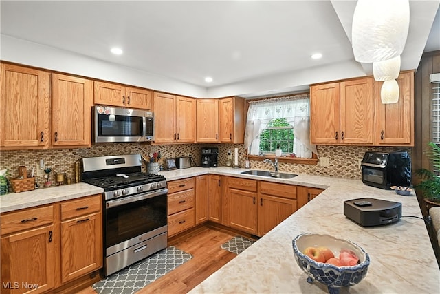 136 Elmridge Rd, Mansfield, OH 44907 - kitchen featuring appliances with stainless steel finishes, tasteful backsplash, light wood-style floors, recessed lighting, and brown cabinets