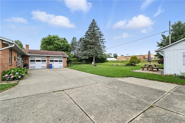 136 Elmridge Rd, Mansfield, OH 44907 - view of green lawn featuring a garage and concrete driveway