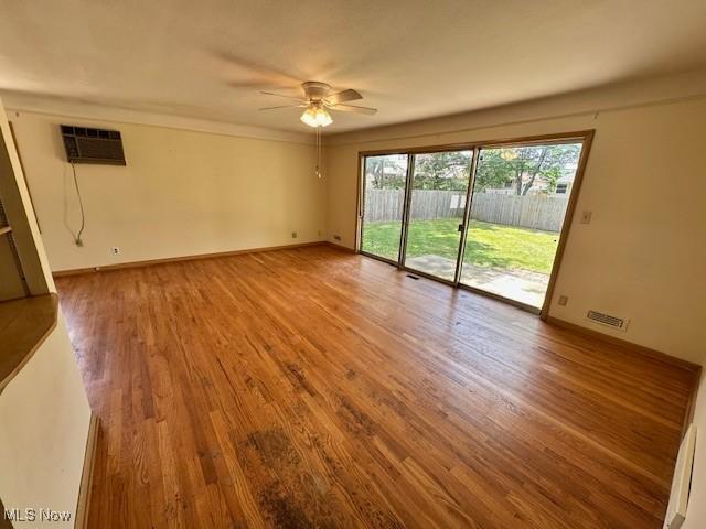8375 Royal Ridge Dr, Parma, OH 44129 - spare room featuring a wall unit AC, ceiling fan, and wood finished floors