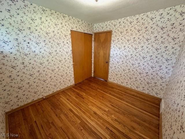 8375 Royal Ridge Dr, Parma, OH 44129 - spare room with wallpapered walls and wood finished floors