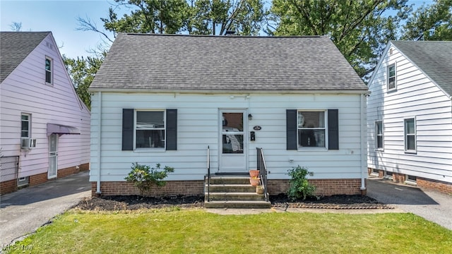 21100 Watson Rd, Maple Heights, OH 44137 - cape cod house featuring entry steps, a front lawn, a shingled roof, and driveway