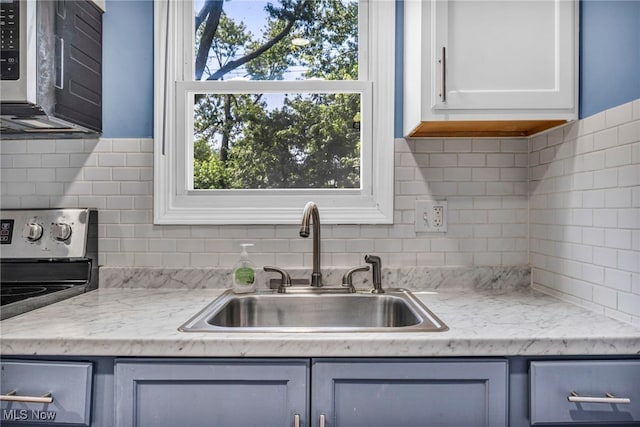 21100 Watson Rd, Maple Heights, OH 44137 - kitchen with stainless steel microwave, light countertops, range, and decorative backsplash