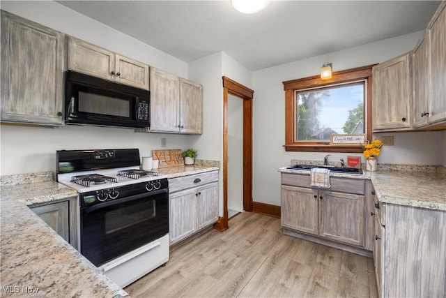 1029 S Main St, Grafton, OH 44044 - kitchen featuring black microwave, gas range oven, and light wood finished floors