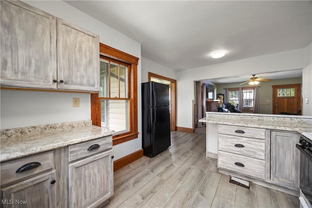 1029 S Main St, Grafton, OH 44044 - kitchen with freestanding refrigerator, light wood finished floors, a ceiling fan, stove, and open floor plan