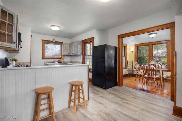 1029 S Main St, Grafton, OH 44044 - kitchen with black appliances, light wood-style floors, a peninsula, and light countertops