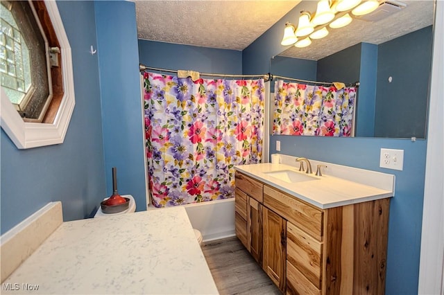 9306 Beech St, Louisville, OH 44641 - full bath featuring vanity, wood finished floors, a textured ceiling, shower / bath combination with curtain, and a chandelier