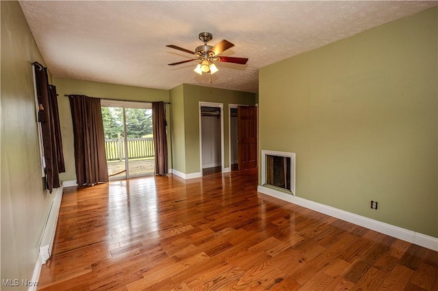 9306 Beech St, Louisville, OH 44641 - empty room featuring wood finished floors, a textured ceiling, a baseboard heating unit, and ceiling fan